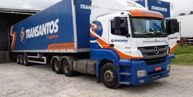 A foto mostra uma carreta da empresa Transantos Transportes e Logística 
