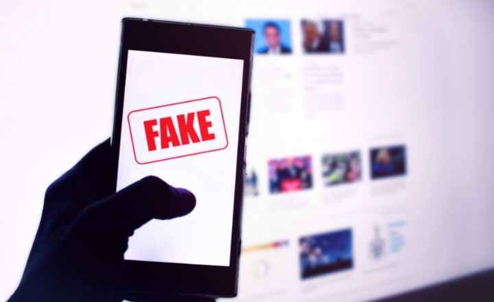 Imagem mostra Fake News sendo mostrada no celular e notebook