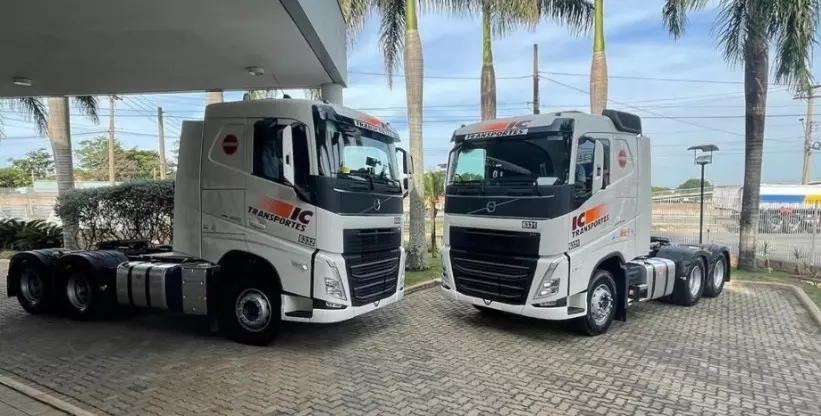 Foto mostra a frota de caminhões da empresa IC Transportes