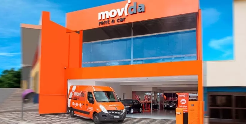 A foto mostra a van da Movida parada em frente a loja da Movida