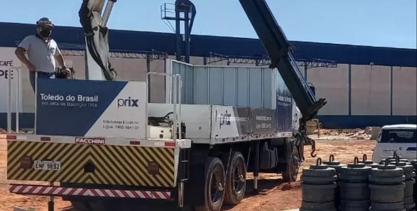 A foto mostra um operador de Guindauto em cima do caminhão Guindauto da empresa Toledo do Brasil