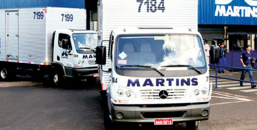 A foto mostra dois caminhões baú da frota do Martins Atacado